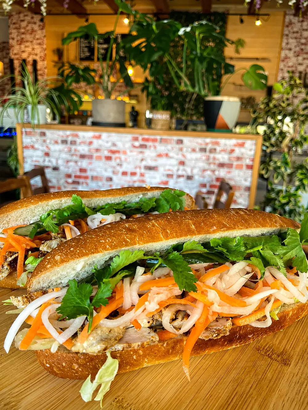 A filled N’Joy sandwich with fresh vegetables, photographed by the cafe counter
