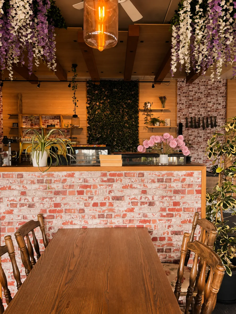 N’Joy’s brick counter, hanging flowers and wooden tables